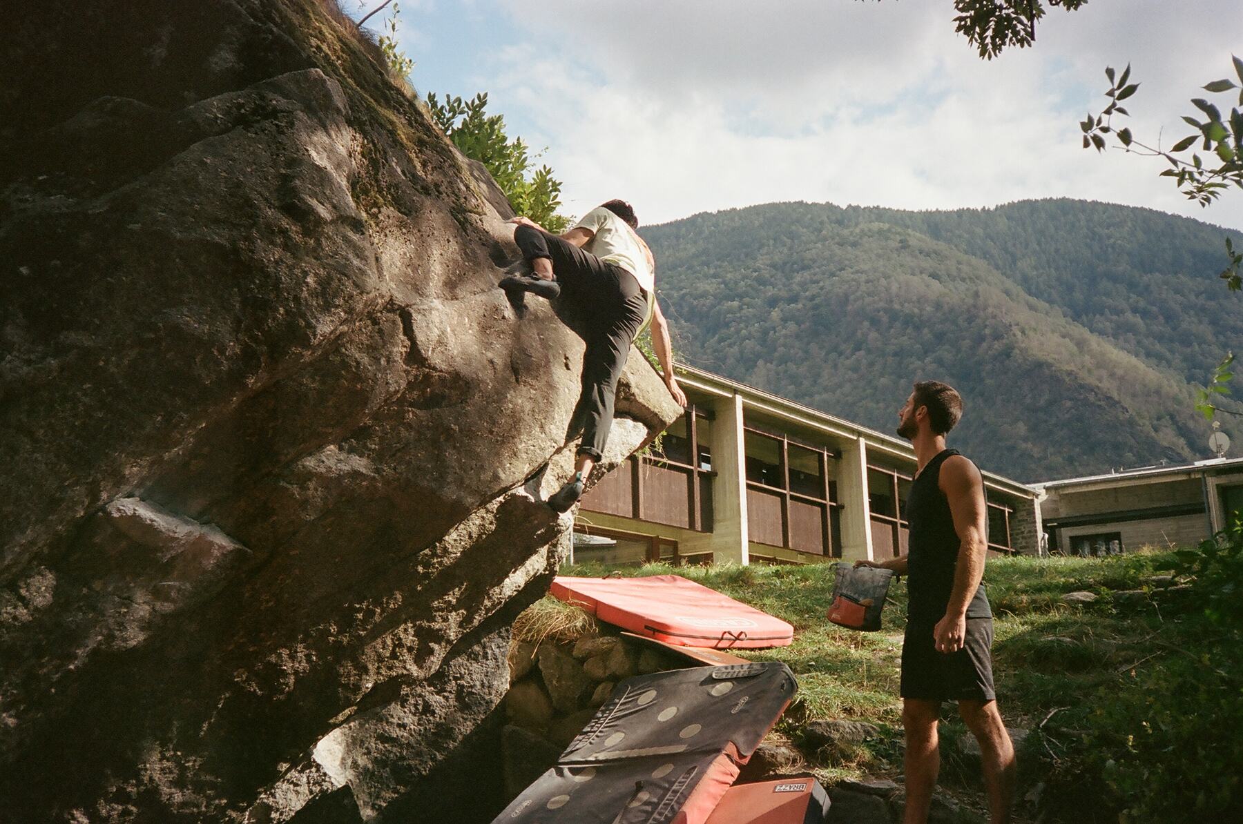 one climber topping out while another spots, shot on film